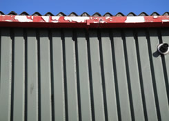 This image also shows the extent of the dilapidation to the steel cladding and metal casement box gutters prior to Weston Painting Contractors applying the Crown water base metal primer coat.